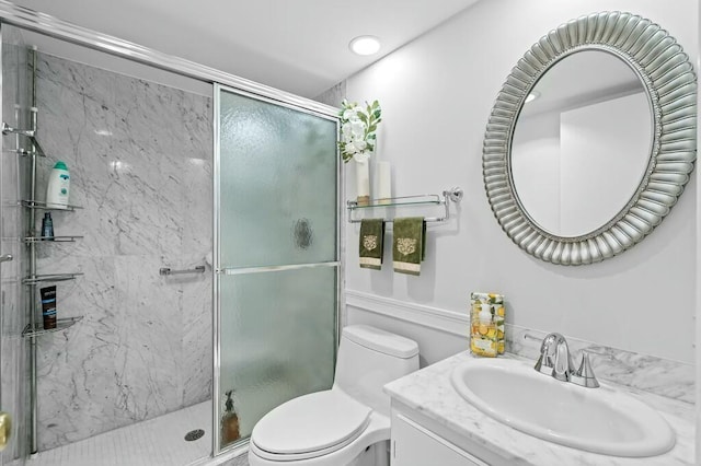 bathroom featuring vanity, an enclosed shower, and toilet