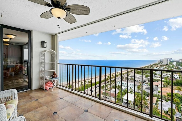 balcony with a water view and a view of the beach