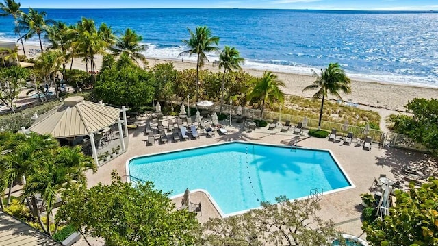 view of pool with a view of the beach, a water view, and a patio area