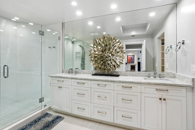 bathroom featuring vanity and a shower with door