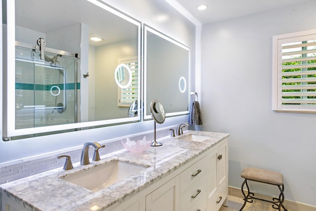 bathroom featuring decorative backsplash, vanity, and an enclosed shower