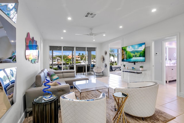 tiled living room with ceiling fan and sink