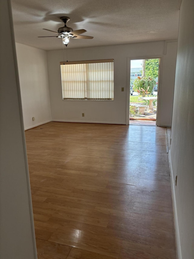 spare room with ceiling fan, a textured ceiling, and light hardwood / wood-style flooring