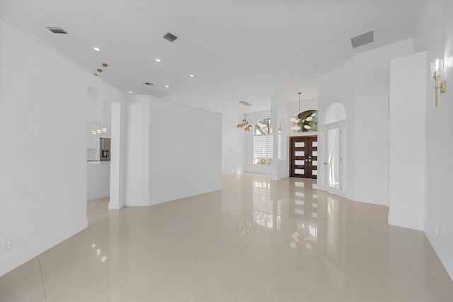 spare room with a chandelier and light tile patterned flooring