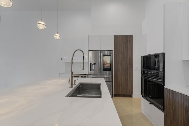 kitchen with stainless steel fridge, sink, decorative light fixtures, white cabinetry, and oven