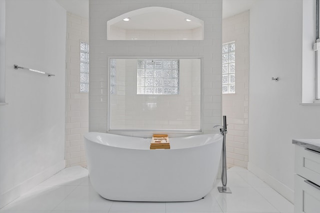 bathroom featuring tile patterned flooring, vanity, and a tub