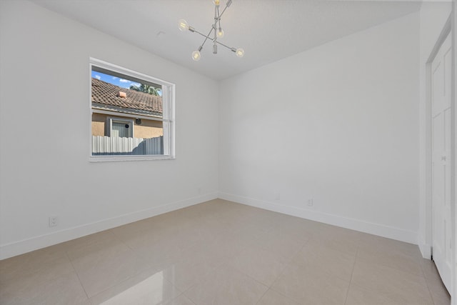 empty room featuring light tile patterned floors and an inviting chandelier