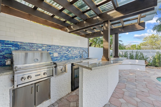 view of patio featuring a grill, area for grilling, a pergola, and an outdoor wet bar