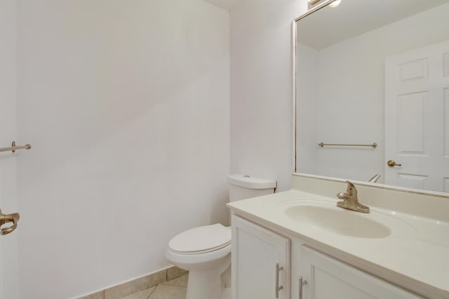 bathroom with toilet, vanity, and tile patterned floors