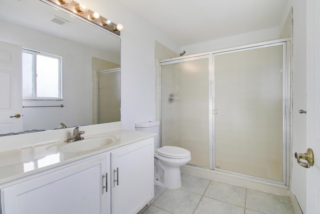 bathroom featuring vanity, toilet, walk in shower, and tile patterned floors