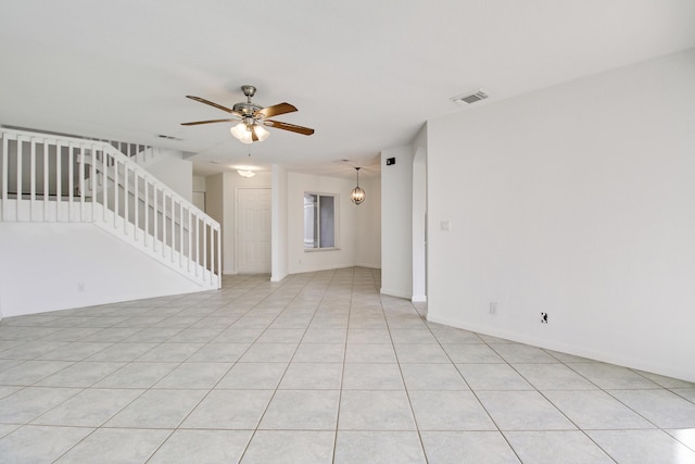 tiled spare room featuring ceiling fan