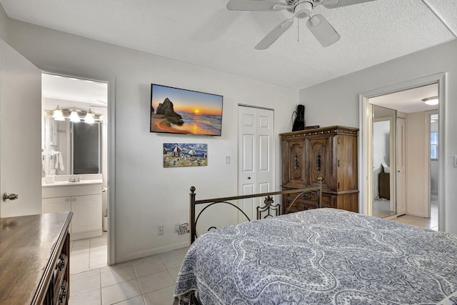 bedroom featuring ensuite bathroom, sink, ceiling fan, light tile patterned flooring, and a closet