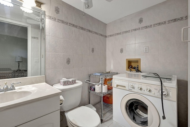 bathroom featuring ceiling fan, washer / dryer, toilet, vanity, and tile walls