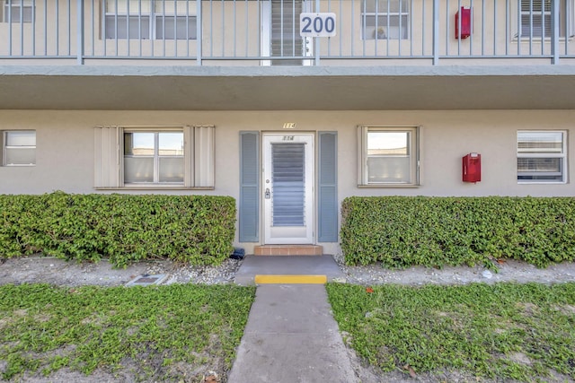 view of exterior entry with a balcony