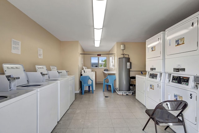 laundry room with stacked washer / drying machine, light tile patterned flooring, washing machine and clothes dryer, and water heater