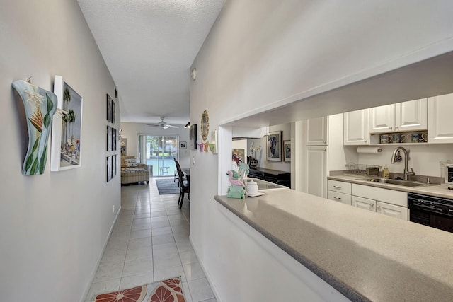 hall featuring sink, light tile patterned floors, and a textured ceiling