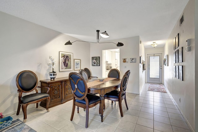 tiled dining room with a textured ceiling