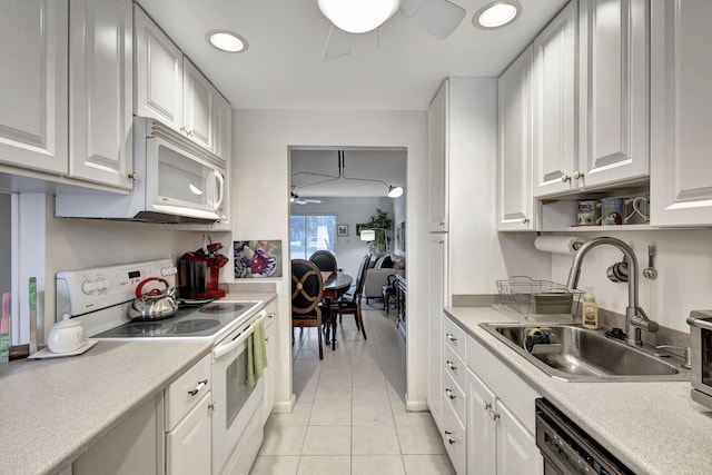 kitchen featuring white cabinetry, sink, light tile patterned floors, and white appliances