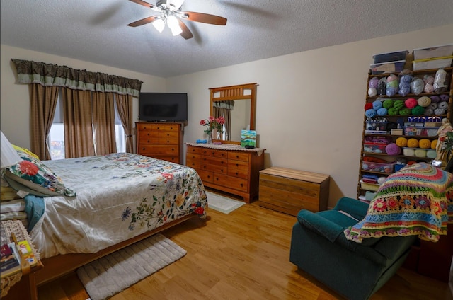 bedroom featuring ceiling fan, wood-type flooring, and a textured ceiling