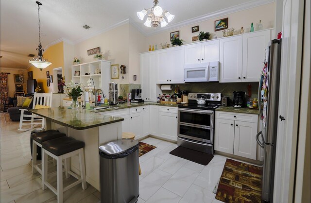 kitchen featuring a kitchen bar, appliances with stainless steel finishes, backsplash, sink, and hanging light fixtures