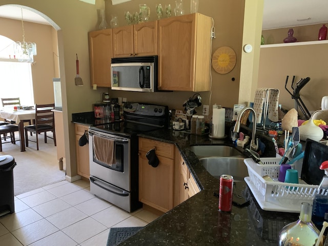 kitchen with sink, stainless steel appliances, a chandelier, light colored carpet, and light brown cabinetry