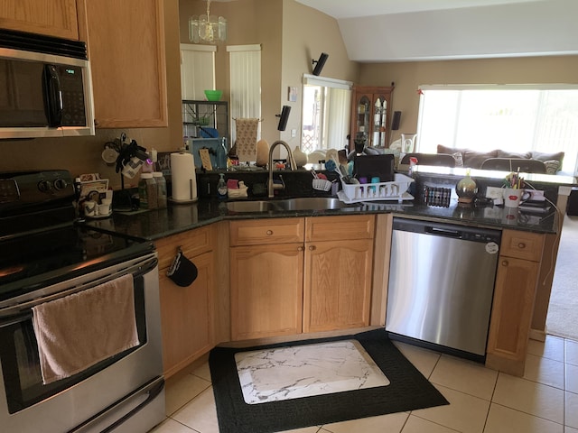 kitchen featuring kitchen peninsula, sink, light tile patterned floors, and stainless steel appliances