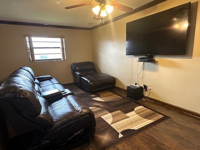 living room with dark hardwood / wood-style floors, ceiling fan, and ornamental molding