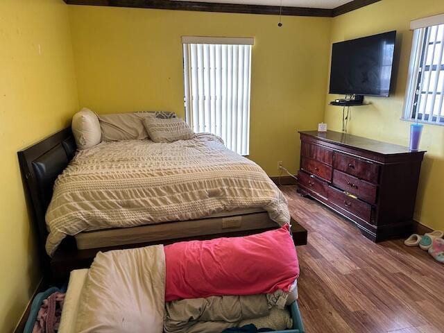 bedroom featuring wood-type flooring and ornamental molding