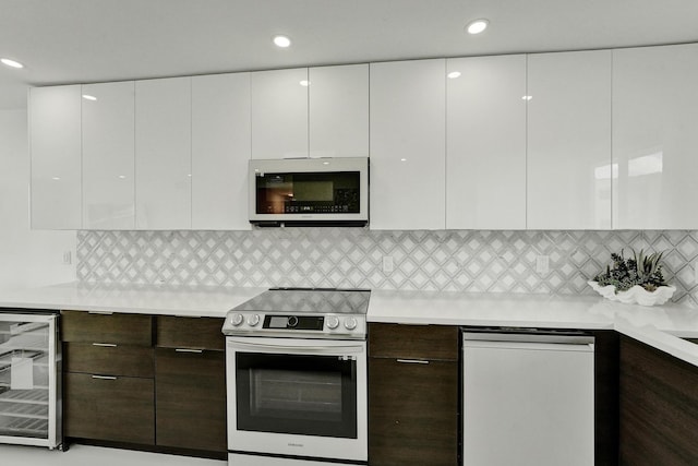 kitchen with stainless steel electric stove, dark brown cabinetry, white cabinetry, and beverage cooler