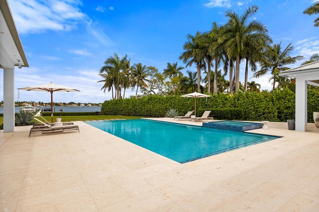 view of swimming pool with an in ground hot tub, a water view, and a patio area