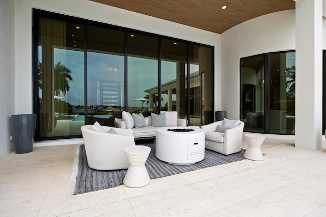 view of patio with an outdoor living space with a fire pit