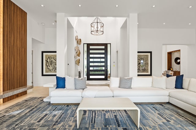 unfurnished living room featuring a towering ceiling and an inviting chandelier