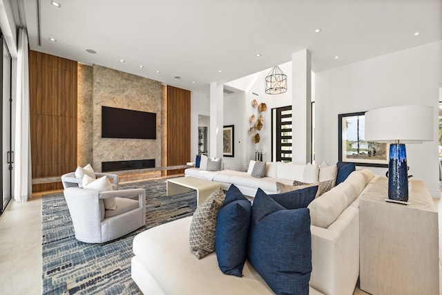 living room with a towering ceiling, a notable chandelier, and a fireplace