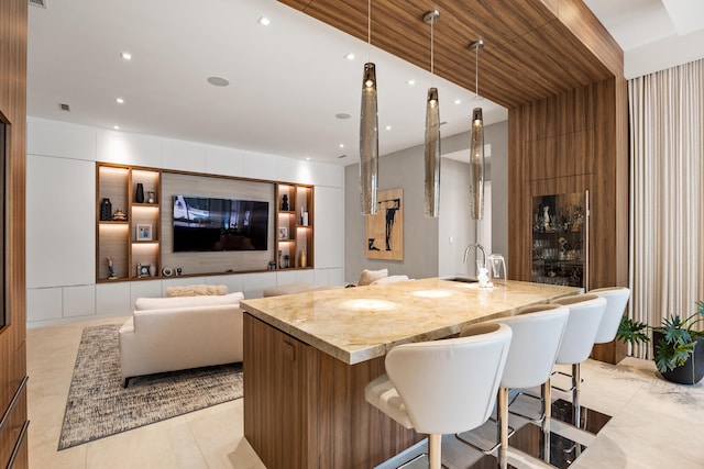 kitchen with hanging light fixtures and light stone counters