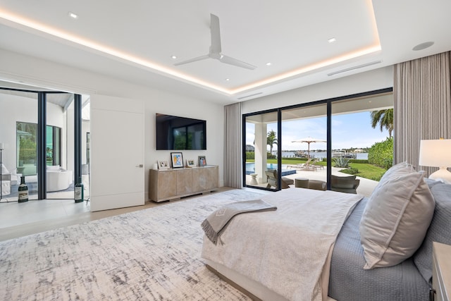 bedroom with ceiling fan, a raised ceiling, and access to outside