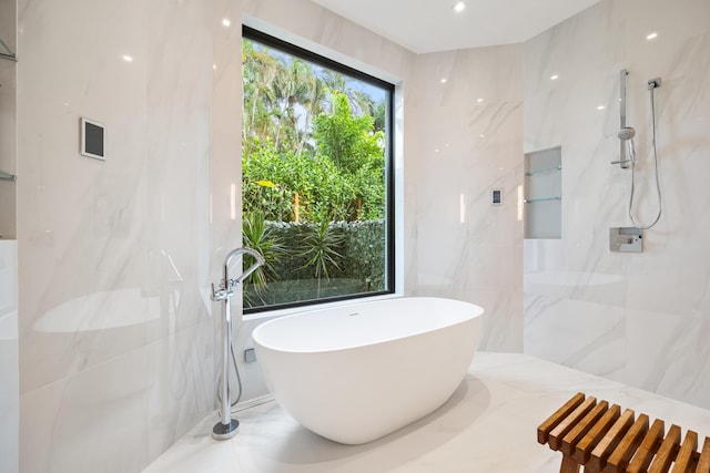 bathroom featuring shower with separate bathtub