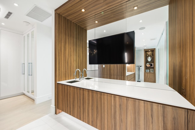 bar with sink and light tile patterned floors