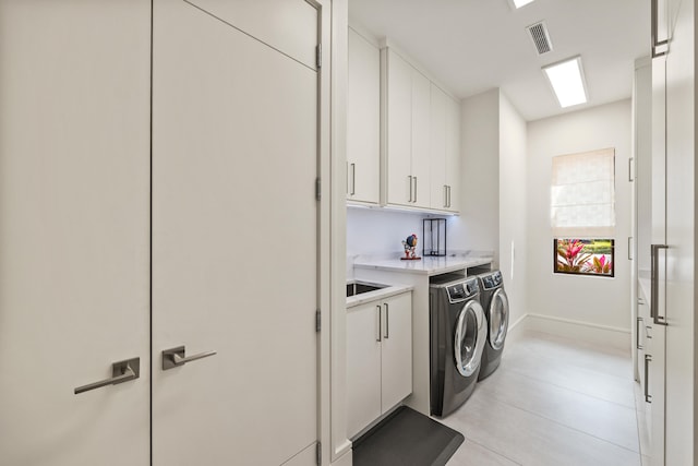 laundry room featuring cabinets and washing machine and dryer