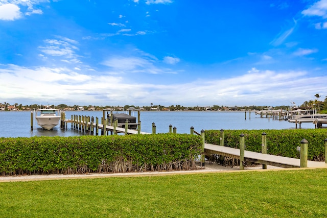 view of dock featuring a lawn and a water view