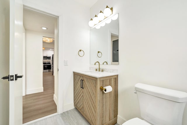 bathroom featuring hardwood / wood-style floors, vanity, and toilet