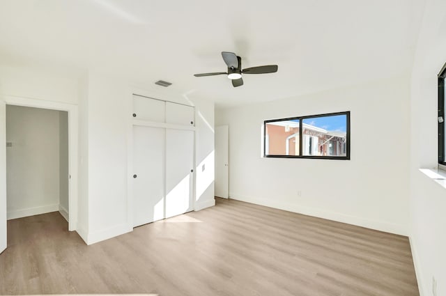 unfurnished bedroom featuring ceiling fan, light wood-type flooring, and a closet