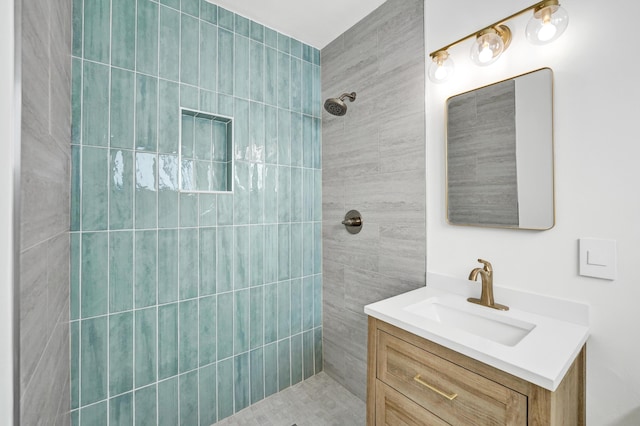 bathroom featuring a tile shower and vanity