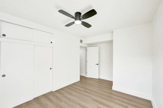 unfurnished bedroom featuring ceiling fan, a closet, and light hardwood / wood-style flooring