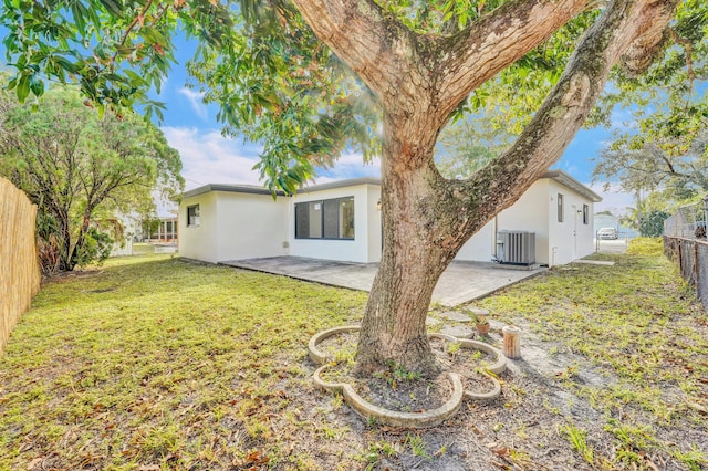 back of property with a yard, a patio, and central AC unit