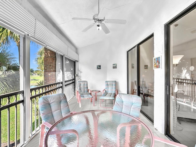 dining space with ceiling fan with notable chandelier, lofted ceiling, and light tile patterned flooring