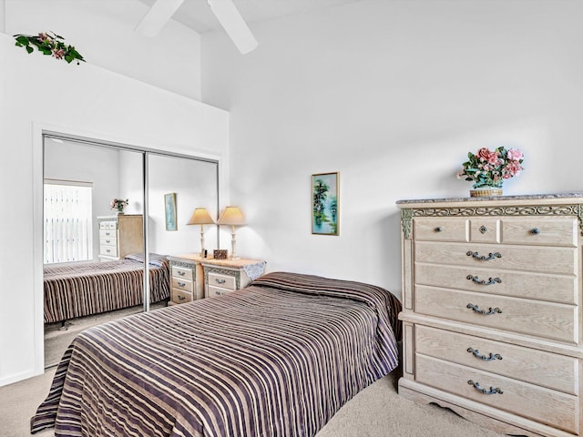 bedroom featuring beamed ceiling, ceiling fan, light colored carpet, and a closet