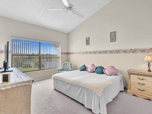 bedroom featuring a textured ceiling, light colored carpet, and ceiling fan