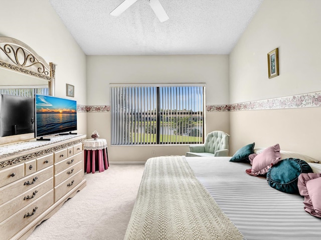 carpeted bedroom featuring a textured ceiling and ceiling fan