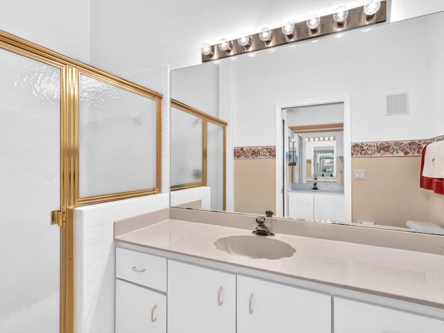 bathroom featuring vanity and a shower with shower door