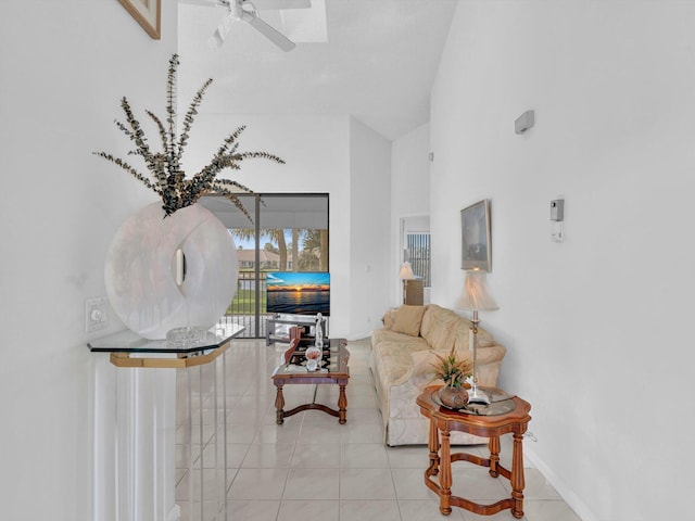 tiled living room featuring ceiling fan and high vaulted ceiling